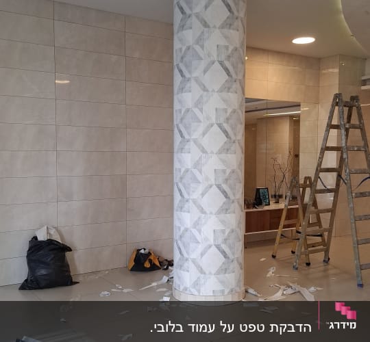 עמוד עטוף בטפטים עם סולם ופסולת על הרצפה